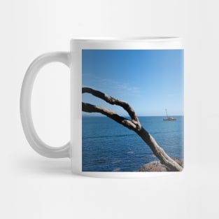 View through twisted pohutukawa tree branches across barge with crane blue ocean to distant horizon Mug